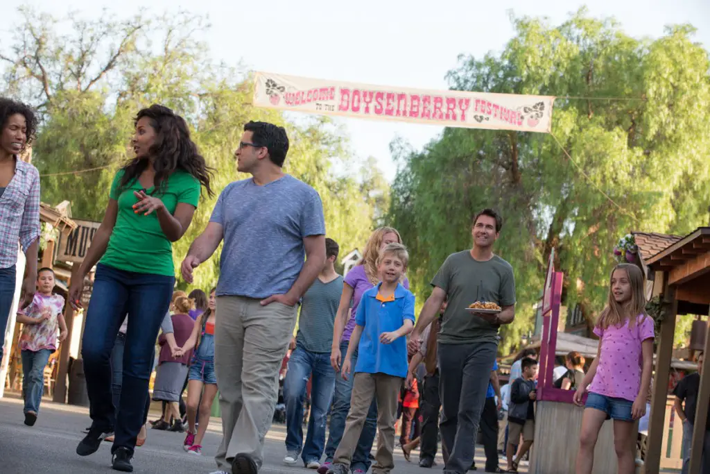 Group walking with Boysenberry Festival Banner Behind